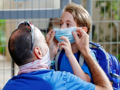 Un père ajuste le masque de sa fille le jour de la rentrée scolaire, le 1er septembre 2020 à Tel Aviv - JACK GUEZ [AFP]