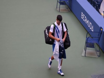 Le Serbe Novak Djokovic quitte le court après sa disqualification pour un geste d'humeur lors du 8e de finale de l'US Open face à l'Espagnol Pablo Carreno, à New York, le 6 septembre 2020 - AL BELLO [GETTY IMAGES NORTH AMERICA/AFP]