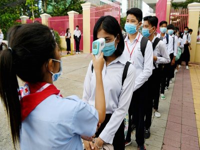 Des élèves masqués se font prendre leur température le 7 septembre à Phnom Penh au Cambodge, lors de la rentrée des classes - TANG CHHIN Sothy [AFP]