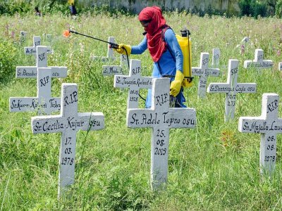 Un employé municipal désinfecte un cimetière catholique après les funérailles de victimes du Covid-19 le 6 septembre 2020 - - [AFP]