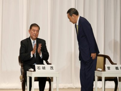 Le secrétaire général du gouvernement Yoshihide Suga (d) avant sa conférence de presse devant l'ancien ministre de la Défense Shigeru Ishiba (g), le 8 septembre 2020 à Tokyo - Du Xiaoyi [POOL/AFP]