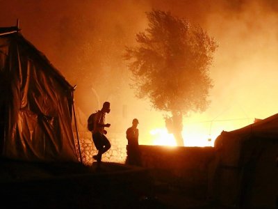 Des migrants dans le camp en feu de Moria, sur l'île grecque de Lesbos, le 9 septembre 2020 - Manolis LAGOUTARIS [AFP]