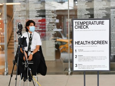 Un employé contrôle la température des visiteurs à l'entrée du Whitney Museum of American Art, le 3 septembre 2020 à sa réouverture à New York - Angela Weiss [AFP/Archives]