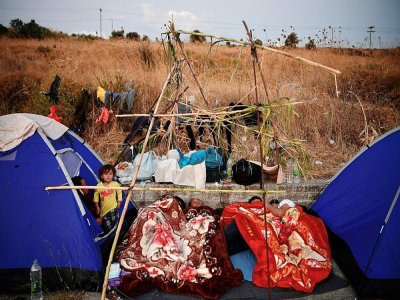 Une famille de réfugiés installée dans un champ, le 12 septembre 2020, après l'incendie du camp de Moria, sur l'île de Lesbos en Grèce - LOUISA GOULIAMAKI [AFP]
