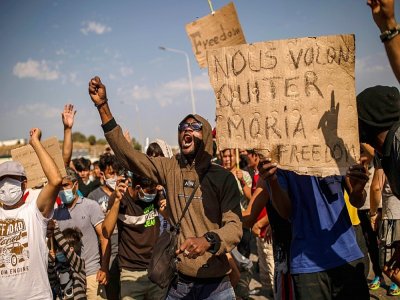 Des migrants et demandeurs d'asile manifestent à Lesbos, en Grèce, le 12 septembre 2020, pour demander à quitter l'île pour d'autres pays européens - ANGELOS TZORTZINIS [AFP]