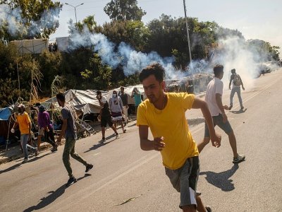 La police grecque utilise des gaz lacrymogènes contre des migrants rendus sans abri par l'incendie du camp de Moria, sur l'île de Lesbos en Grèce, qui manifestent pour demander à quitter l'île, le 12 septembre 2020 - ANGELOS TZORTZINIS [AFP]