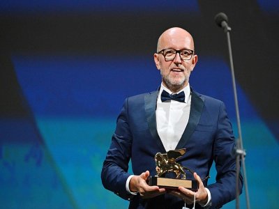 Le directeur marketing de Disney pour l'Italie, Davide Romani, reçoit le Lion d'Or du 77e festival du film de Venise au nom de la cinéaste américaine Chloé Zhao pour le film "Nomadland" , le 12 septembre 2020 à Venise - Alberto PIZZOLI [AFP]