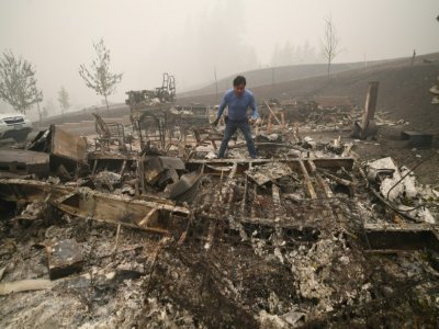 Marcelino Maceda fouille dans les décombres de son mobile home à Estacada (Oregon) le 12 septembre 2020 - Robyn Beck [AFP]