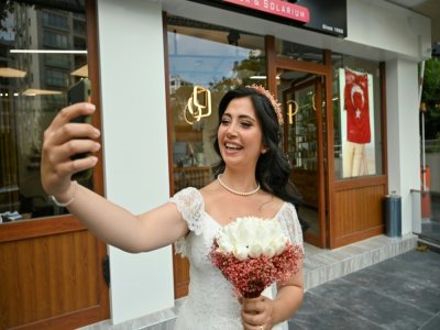 La Turque de 28 ans Ayse Keles prend un selfie devant le salon de coiffure où elle s'est rendue avant ses photos de mariage le 5 septembre 2020 à Istanbul - Ozan KOSE [AFP]