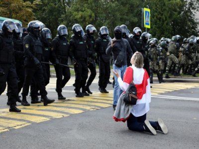 Une femme se met à genoux devant les policiers pendant une manifestation contre la réélection controversée du président Alexandre Loukachenko le 13 septembre 2020 à Minsk - -, - [TUT.BY/AFP]