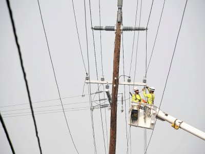 Des ouvriers réparent les liges électriques à Phoenix (Oregon) le 15 septembre 2020 - Robyn Beck [AFP]