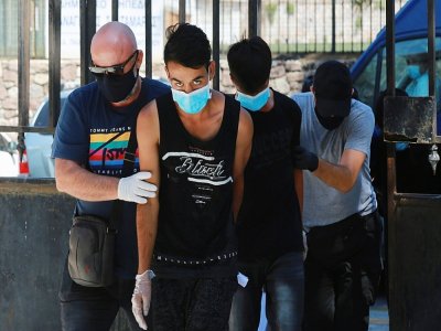 De jeunes migrants afghans arrêtés pour leur implication dans l'incendie arrivent au tribunal à Lesbos le 16 septembre 2020 - Manolis LAGOUTARIS [AFP]