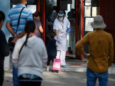 Une infirmière désinfecte les mains d'une enfant à l'entrée d'un centre de soin, le 21 septembre 2020 à Madrid, pendant un reconfiment partiel - OSCAR DEL POZO [AFP]