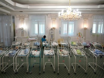 Une infirmière s'occupe de nouveaux-nés parmi la centaine de bébés nés de mères porteuses bloqués en Ukraine par la pandémie, à l'Hôtel Venice à Kiev le 15 mai 2020 - SERGEI SUPINSKY [AFP/Archives]