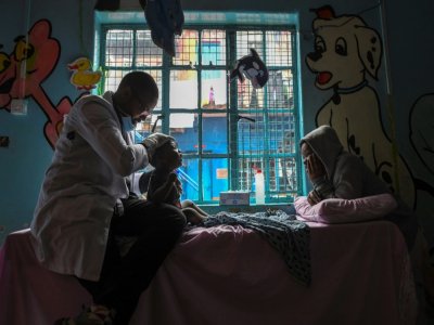 Le thérapeut Dennis Mandera s'occupe d'un jeune enfant atteint de handicap dans un centre spécialisé du bidonville de Mathare, le 8 septembre 2020 à Nairobi, au Kenya - TONY KARUMBA [AFP]
