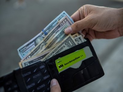 Un homme montre son porte-monnaie contenant des dollars américains dans une rue de La Havane, le 15 septembre 2020 à Cuba - YAMIL LAGE [AFP]