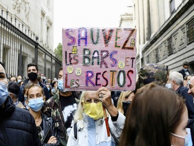 n homme brandit une pancarte proclamant "Sauvez les bars et les restos" lors d'une manifestation à Marseille le 25 septembre 2020 - NICOLAS TUCAT [AFP]