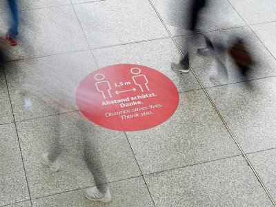 Un autocollant sur le sol appelle à respecter la distanciation physique dans la gare de Munich, en Allemagne, le 25 septembre 2020 - Christof STACHE [AFP]