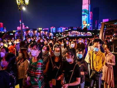 Des passagers portant des masques pour éviter de propager le coronavirus attendent d'embarquer dans un bateau pour regarder un spectacle, à Wuhan le 27 septembre 2020 - Hector RETAMAL [AFP/Archives]