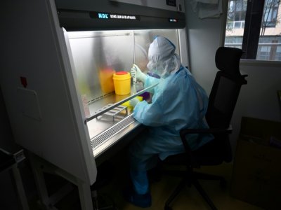 Un technicien manipule des échantillons dans un laboratoire de l'entreprise chinoise de biotechnologie Coyote, avant de les tester dans le Flash 20, une machine de dépistage rapide au nouveau coronavirus, le 27 septembre 2020 à Pékin - GREG BAKER [AFP]