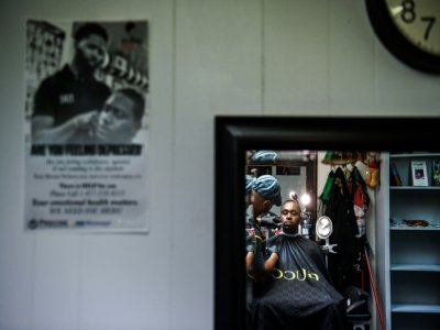 Antonio Wiggins (G) coupe les cheveux de James Bennett dans son salon, à Jackson, le 26 septembre 2020 - CHANDAN KHANNA [AFP]