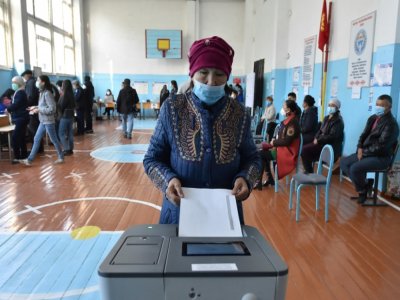 Une vieille dame place son bulletin dans l'urne pour les élections législatives kizghizes  dans le village de Bech-Kungey, près de Bichkek, le 4 octobre 2020 - VYACHESLAV OSELEDKO [AFP]