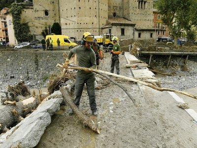 Des équipes de secours enlèvent des arbres tombés sur un pont à Breil-sur-Roya (sud-est de la France), le 4 octobre 2020 - NICOLAS TUCAT [AFP]