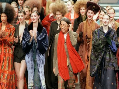 Le styliste japonais Kenzo entouré par des mannequins à l'issue de la présentation de sa collection de prêt-à-porter Automne-Hiver, en mars 1998 à Paris - Joël SAGET [AFP/Archives]