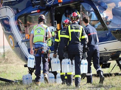 Des packs d'eau sont transportés vers un hélicoptère le 5 octobre 2020 à Breil-sur-Roya (Alpes-Maritimes) - Valery HACHE [AFP]