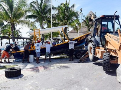 Des pêcheurs et employés mettent à l'abri des bateau avant l'arrivée de l'ouragan Delta, le 6 octobre 2020 à Puerto Morelos, au Mexique - ELIZABETH RUIZ [AFP]