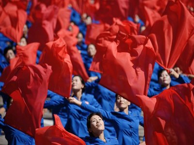 Des participants agitant des fleurs lors d'un défilé le 9 septembre 2018 à Pyongyang - Ed JONES [AFP]