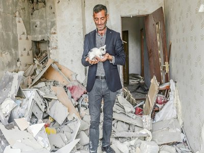 Un homme tient un chaton trouvé dans les ruines de son apartement après un bombardement, le 10 octobre 2020 à Tartar, en Azerbaïdjan - Bulent Kilic [AFP]