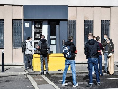 Des policiers devant l'entrée endommagée du commissariat de police de Champigny-sur-Marne, le 11 octobre 2020 - STEPHANE DE SAKUTIN [AFP]