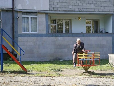 Un vieil homme devant un immeuble à Stepanakert, le 12 octobre 2020 - ARIS MESSINIS [AFP]