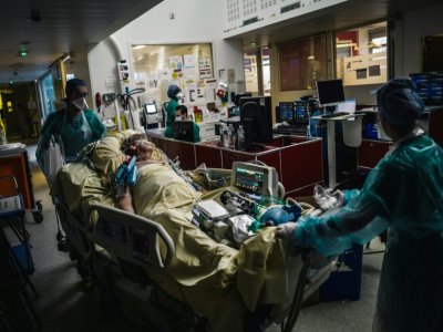 Des soignants transportent un patient à l'unité de soins intensifs de l'hôpital Lariboisière, le 14 octobre 2020 à Paris - LUCAS BARIOULET [AFP]