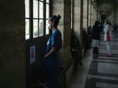Une soignante fait une pause dans un couloir de l'hôpital Lariboisière, le 14 octobre 2020 à Paris - LUCAS BARIOULET [AFP]