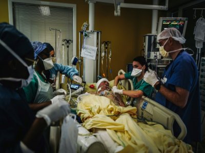 Des soignants s'occupent un patient après une intervention chirurgicale, à l'unité de soins intensifs de l'hôpital Lariboisière, le 14 octobre 2020 à Paris - LUCAS BARIOULET [AFP]