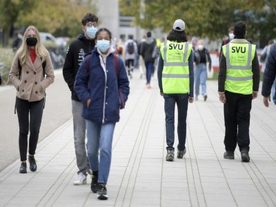 Deux étudiants vestes fluo membres de brigades sanitaires vérifient sur le campus de l'université de Strasbourg, le respect du port du masque, le 15 octobre 2020 - FREDERICK FLORIN [AFP]