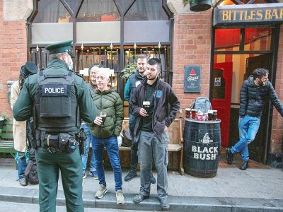 Un policier s'entretient avec les clients d'un bar à Belfast, en Irlande du Nord, le 16 octobre 2020 - Paul Faith [AFP]