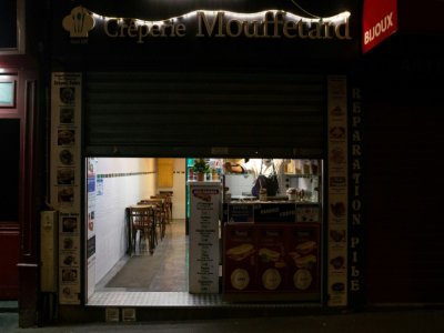 Un restaurant baisse son rideau de fer quelques minutes avant le début du couvre-feu à Paris, le 17 octobre 2020 - Abdulmonam EASSA [AFP]