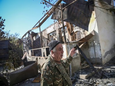 Micha Gyurjian, le maire de Martakert, au Nagorny Karabakh, devant une maison de sa ville détruite par un bombardement, le 19 octobre 2020 - ARIS MESSINIS [AFP]