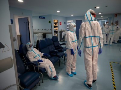 Des soignants en combinaison intégrale de protection font une pause dans l'unité de soins intensifs de l'hôpital universitaire Severo Ochoa, le 16 octobre 2020 à Leganés, dans la banlieue de Madrid - PIERRE-PHILIPPE MARCOU [AFP]