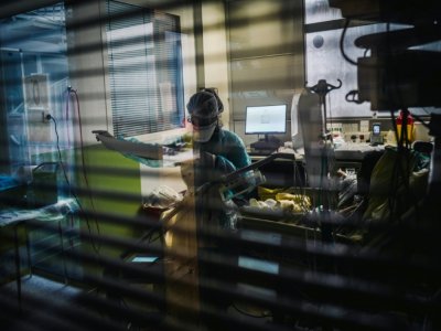 Une soignante s'occupe d'un patient dans l'unité de soins intensifs de l'hôpital Lariboisière, le 14 octobre 2020 à Paris - LUCAS BARIOULET [AFP]
