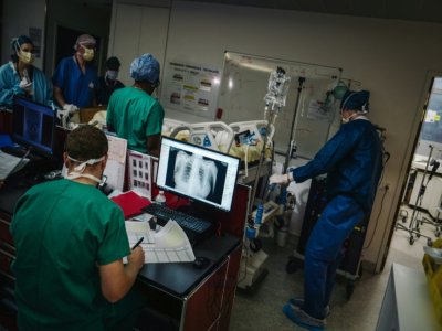 Des équipes soignantes transportent un patient dans l'unité de soins intensifs de l'hôpital Lariboisière, le 14 octobre 2020 à Paris - LUCAS BARIOULET [AFP]
