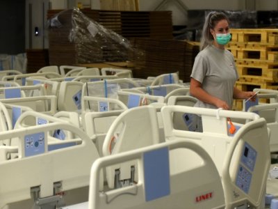 L'employée d'une fabrique de lits d'hôpital tchèque prépare les lits qui seront utilisés pour les patients Covid-19 à Letnany, le 20 octobre 2020 - Michal Cizek [AFP]
