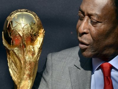 La légende brésilienne du football Pelé regarde le trophée de la Coupe du monde de la FIFA lors d'un événement à Paris, le 9 mars 2014 - FRANCK FIFE [AFP/Archives]