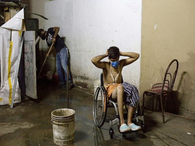 Johan Medina, 31 ans, met un masque après avoir pris un bain dans le sous-sol d'un ministère où il loge dans des conditions déplorables à Caracas, le 9 octobre 2020 - Cristian Hernandez [AFP/Archives]