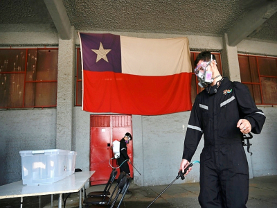 Désinfection d'un bureau de vote avant le référendum sur la Constitution, à Santiago du Chili, le 24 octobre 2020 - PEDRO UGARTE [AFP]