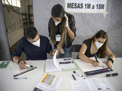 Des membres du service électoral dans les préparatifs d'un bureau de vote à Santiago du Chili, le 24 octobre 2020 - MARTIN BERNETTI [AFP]