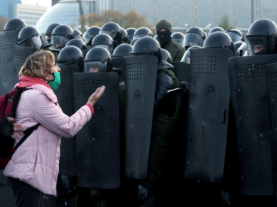 Une femme parle avec des policiers anti-émeute pendant une manifestation à Minsk, le 25 octobre 2020. - Stringer [AFP]